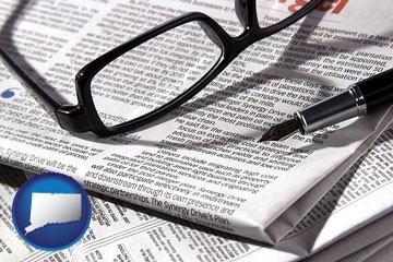 a newspaper, with reading glasses and fountain pen - with Connecticut icon