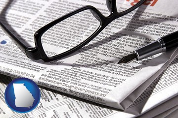 a newspaper, with reading glasses and fountain pen - with Georgia icon