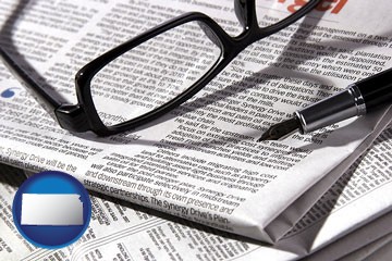 a newspaper, with reading glasses and fountain pen - with Kansas icon