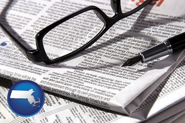 a newspaper, with reading glasses and fountain pen - with Massachusetts icon