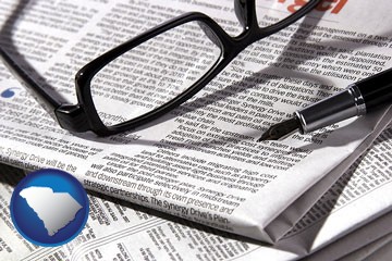 a newspaper, with reading glasses and fountain pen - with South Carolina icon