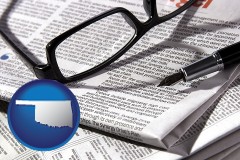 oklahoma map icon and a newspaper, with reading glasses and fountain pen