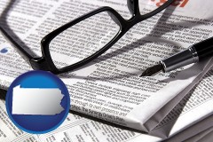 pennsylvania map icon and a newspaper, with reading glasses and fountain pen